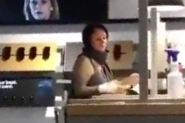 A blurry screenshot from a cellphone video showing a woman who shouted a racial slur in a Manhattan Verizon store after refusing to wear a mask.